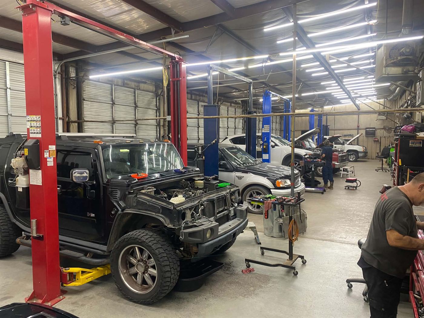 Techs working on vehicles across the service bays at Country Auto Service in McLoud, OK